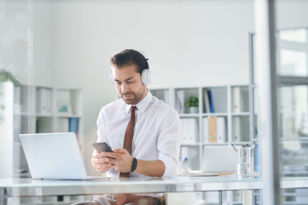 young elegant man in headphones scrolling in smart 2023 11 27 05 29 13 utc Easy Resize.com